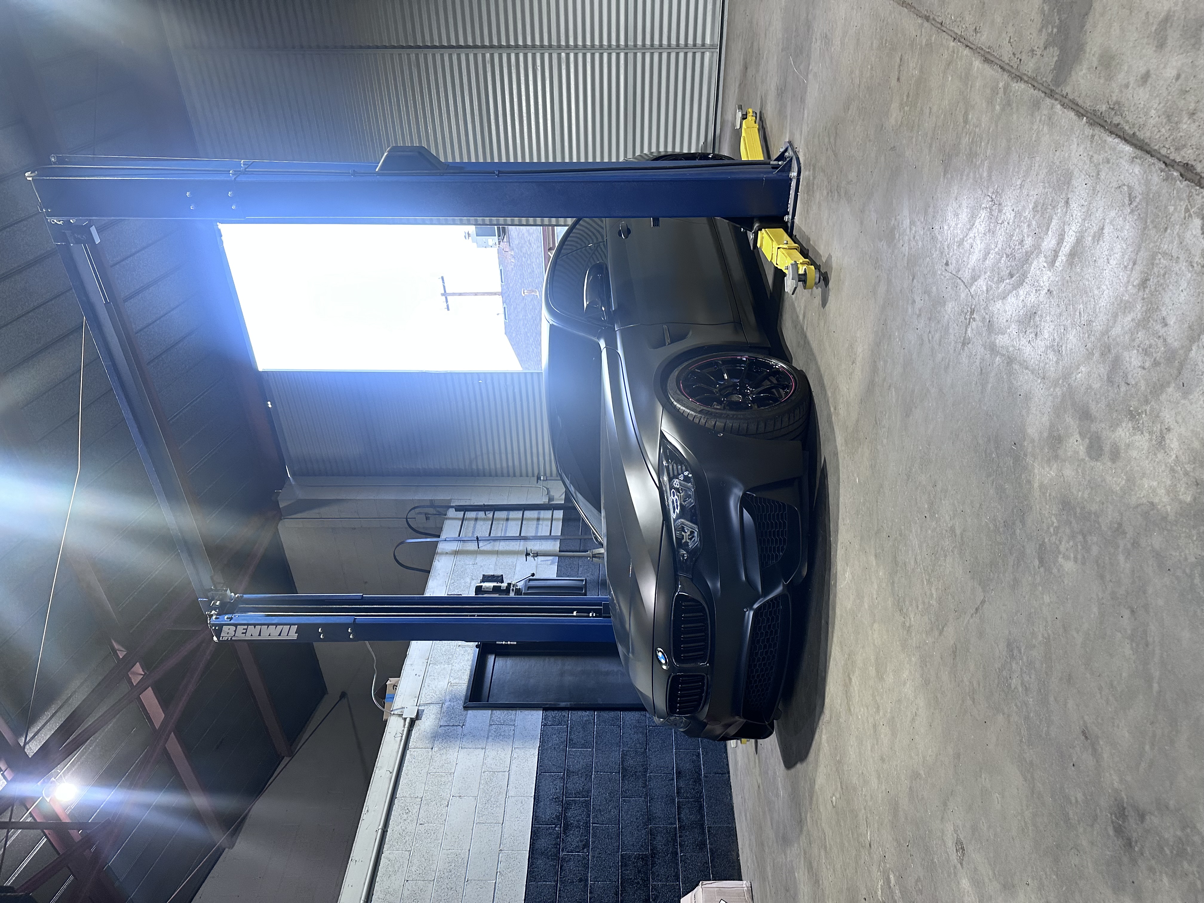 BMW vehicles on lifts receiving comprehensive maintenance service